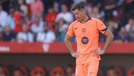 Piłkarz FC Barcelony Robert Lewandowski w pomarańczowym stroju meczowym stoi na boisku ze spuszczoną głową i rękami opartymi na biodrach podczas meczu. Napastnik zmaga się z kolejną kontuzją mięśniową, która może wykluczyć go z gry na kilka spotkań, w tym z El Clasico.