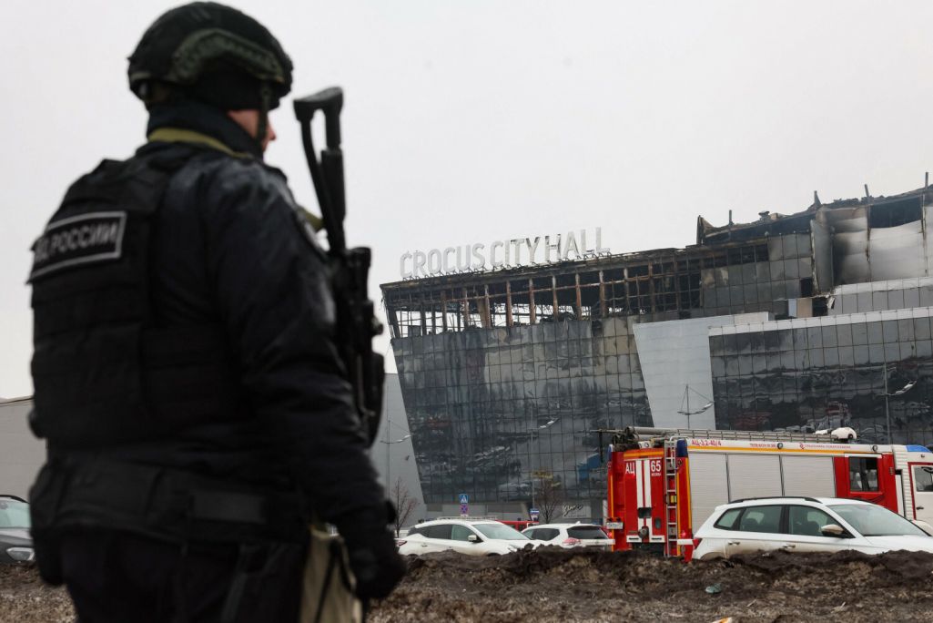 Супрацоўнік праваахоўных органаў патрулюе тэрыторыю каля ГЦ «Crocus City Hall» пасля страляніны. Краснагорск, Расея. 23 сакавіка 2024 года. (Фота: Stringer / AFP / East News)
