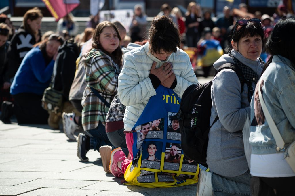 Людзі стаяць на каленях падчас мітынгу з заклікам вызваліць украінскіх ваеннапалонных і вярнуць целы загінулых жаўнераў з перадавой. Кіеў, Украіна. 2 траўня 2025 года. Фота: Danylo Antoniuk / Anadolu via Getty Images