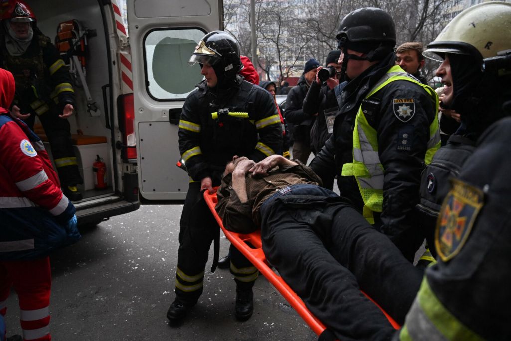 Супрацоўнікі ДСНС заносяць параненага ў машыну хуткай дапамог (Фота: Sergei Supinsky / AFP / East News)