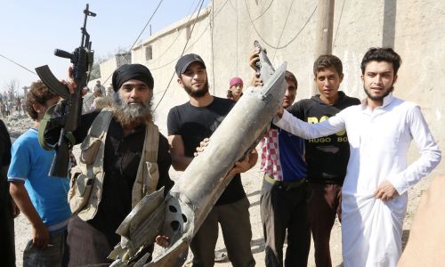 Bojownicy ISIS z kawałkami syryjskiego samolotu strąconego nad miastem, 16 września 2014. Fot. REUTERS/Stringer