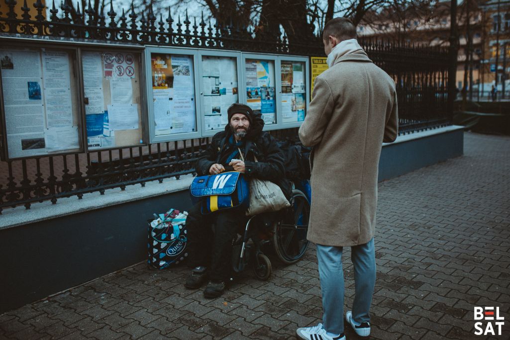 Віктар распавядае пра свой блог чалавеку, які пазнаў яго на вуліцы, бо раней бачыў у інтэрнэце артыкул аб ім. Варшава, Польшча, 11 снежня 2024 года. Фота: Белсат
