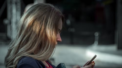 Жанчына глядзіць на смартфон
