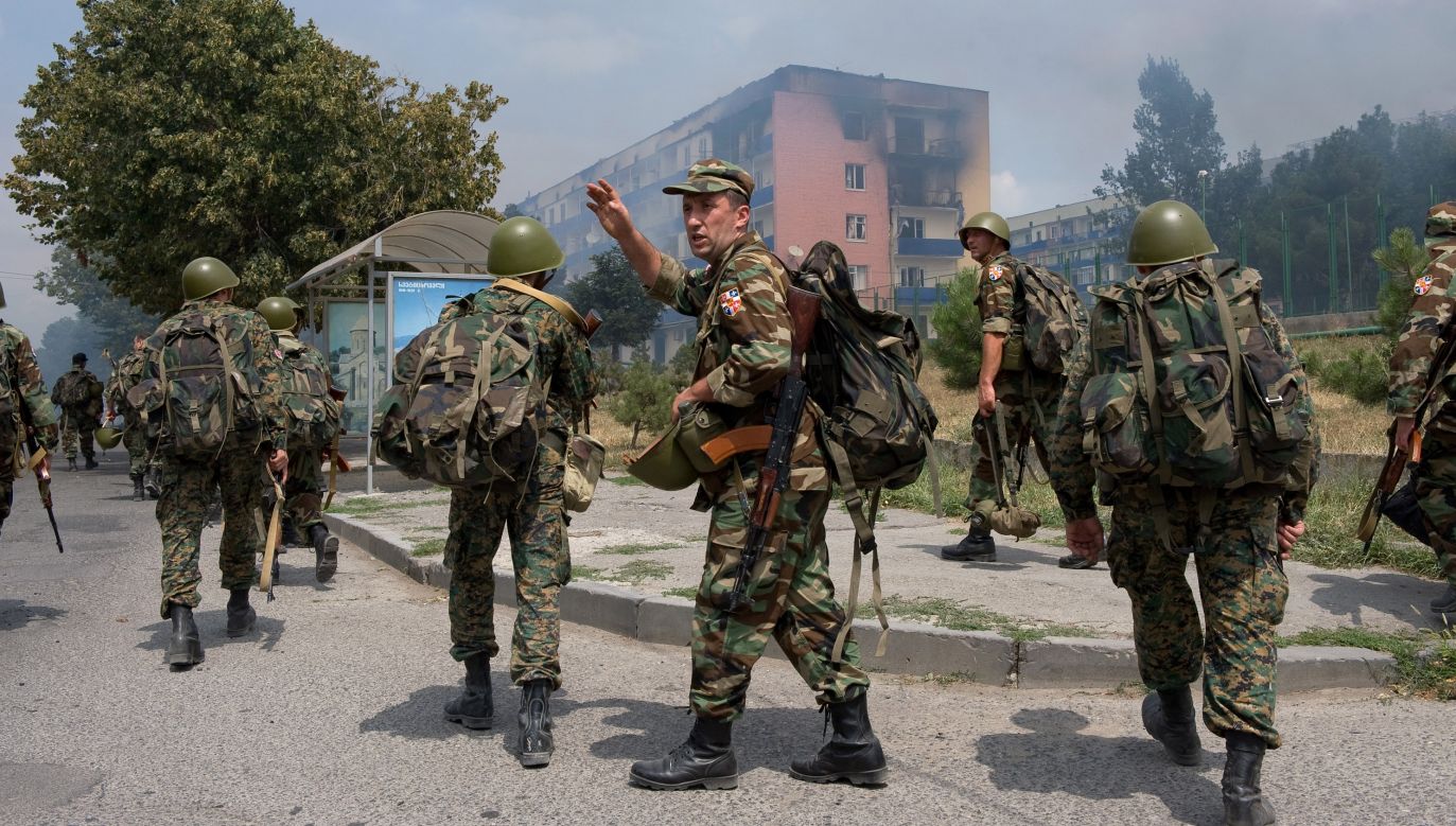 Georgian soldiers march past an apartment building after the area was bombed by Russian jets on August 9, 2008 in Gori, Georgia. Photo: Cliff Volpe/Getty Images