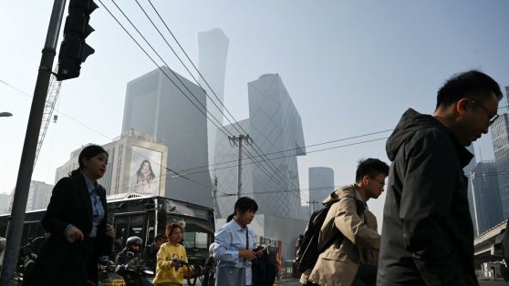 Людзі пераходзяць дарогу ў цэнтральным дзелавым раёне Пекіна, Кітай. 10 красавіка 2025 года. Фота: Greg Baker / AFP / East News