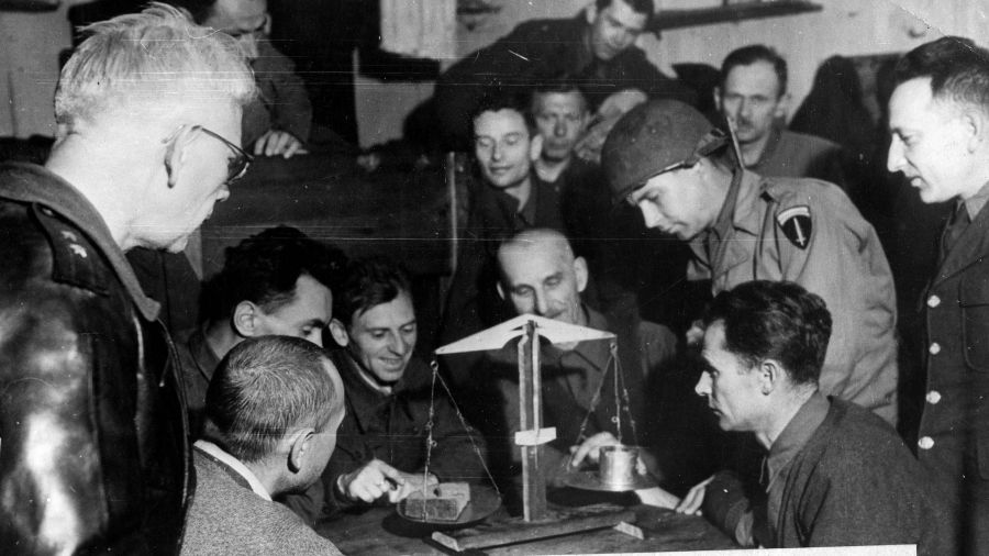 Rok 1945. Po wyzwoleniu.  Żołnierze amerykańscy i byli jeńcy polscy ważą dzienne porcje żywności, jakie otrzymywali więźniowie. Fot. NAC