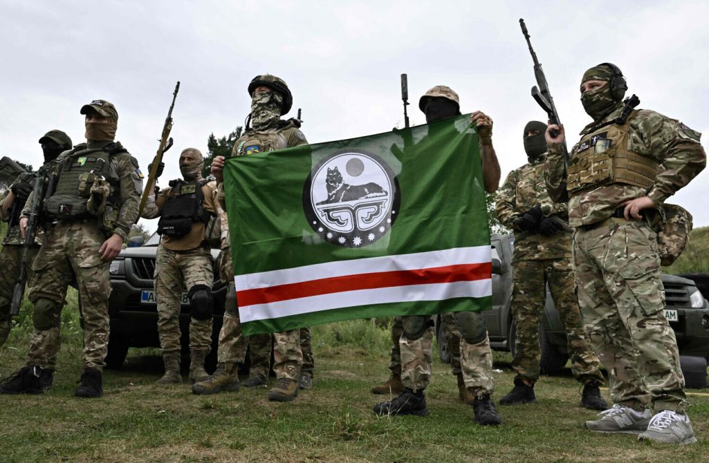 Новыя байцы чачэнскага добраахвотніцкага батальёна імя Джахара Дудаева трымаюць сцяг Чачэнскай Рэспублікі Ічкерыя падчас вучэнняў у Кіеўскай вобласці, Украіна. 27 жніўня 2022 года. Фота: Genya Savilov / AFP / East News