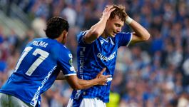 Od lewej: Luis Palma i Kornel Lisman z Lecha Poznań (fot. Getty Images) Na zdjęciu widać dwóch piłkarzy Lecha Poznań w niebieskich koszulkach z logo sponsora „SUPERBET”, przeżywających emocjonalny moment po zakończeniu meczu z Lincoln Red Imps. Zawodnik z numerem 17, Palma, próbuje pocieszyć zrezygnowanego kolegę z drużyny, który trzyma ręce na głowie w geście frustracji. Scena rozgrywa się na tle rozmytego tłumu kibiców, podkreślając napięcie i rozczarowanie towarzyszące spotkaniu, które zakończyło się nie tylko porażką, ale także sankcjami wobec klubu (fot. Getty Images)